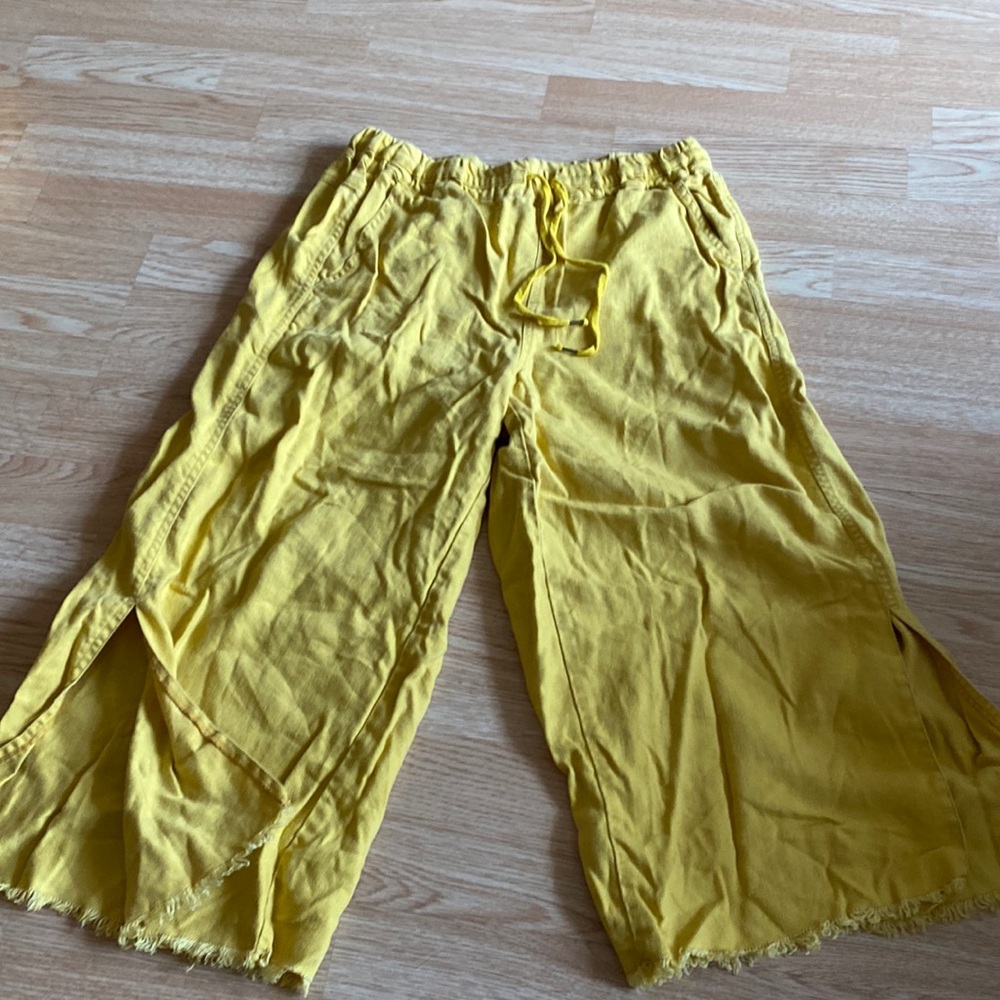 Yellow sweatpants, ripped leg bottoms with slits up the sides